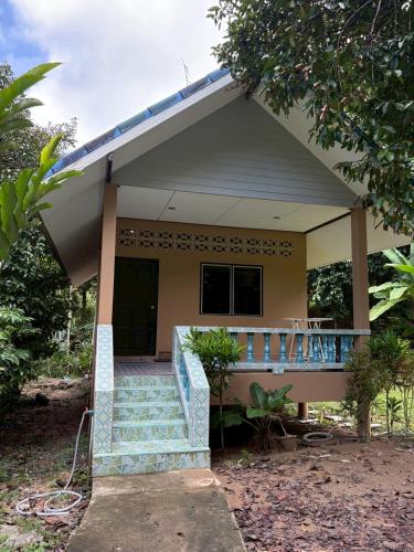 ein kleines Haus mit einer Treppe davor in der Unterkunft Well Living Guesthouse Khaolak in Khao Lak