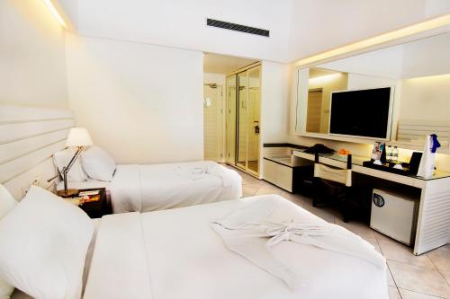 a hotel room with two beds and a television at Nongsa Point Marina in Nongsa