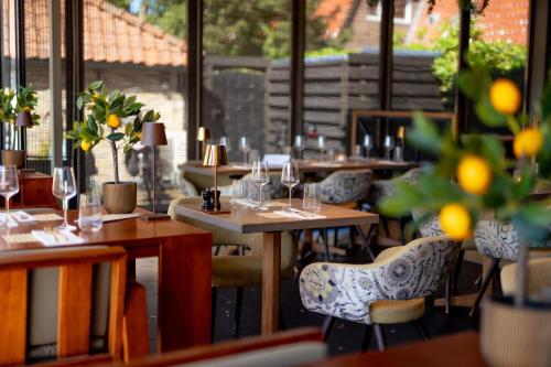 Un restaurante con mesas y sillas con copas de vino. en Nobel - Suites, en Ballum