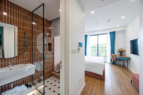 a bathroom with a tub and a sink and a bedroom at Solara Apartment Firework & Sunset View in Phú Quốc