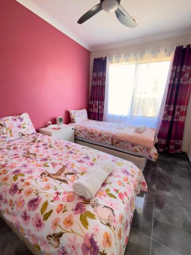 two beds in a bedroom with pink walls at Mahzan on Dromana Room 4 in Truganina
