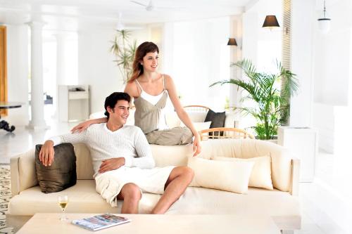 a man and woman sitting on a couch in a living room at Nongsa Point Marina in Nongsa