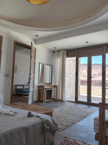 a bedroom with a bed and sliding glass doors at Villa A'Kabar Guest House in Aït Benhaddou