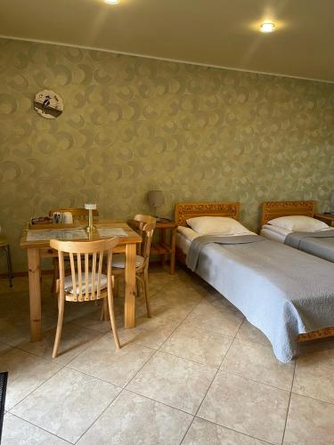 ein Schlafzimmer mit zwei Betten, einem Tisch und Stühlen in der Unterkunft Dzeņi in Amatciems