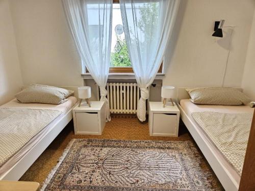 two beds in a room with a window at Ferienwohnung Stadtmitte in Braunfels