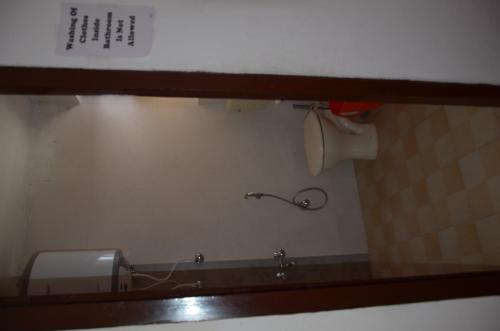a reflection of a sink in a bathroom mirror at Howrah Guest House in Srinagar