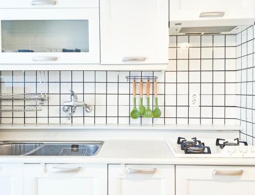 a kitchen with white cabinets and a sink at Aurora Stay in Pongsan-dong