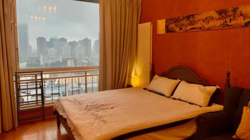 a bedroom with a bed and a large window at Beijing City center - Two bedroom family flat with Queen-size beds in Beijing
