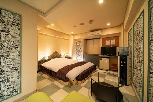 a bedroom with a large bed and a kitchen at Hotel Xenia Mikumo (Adult Only) in Konan