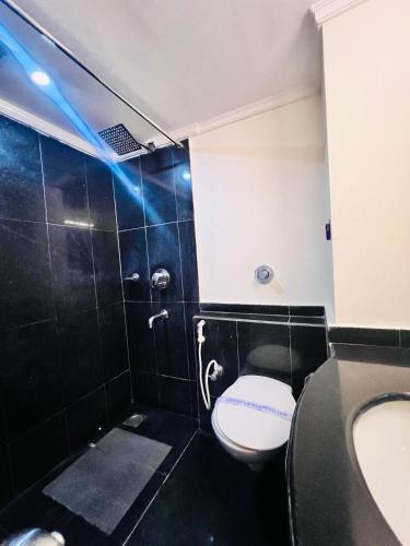 a bathroom with a toilet and a sink at Hotel Dr Rajkumar International in Bangalore