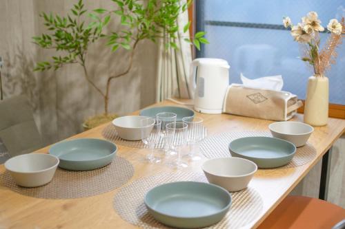 a wooden table with plates and bowls on it at ever Inn Asagaya in Tokyo