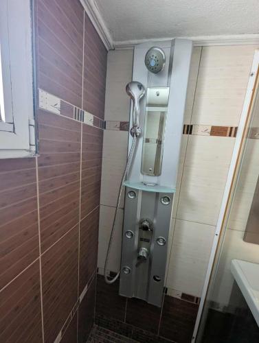 a shower in a bathroom with a mirror on the wall at Byron suite in Kavála