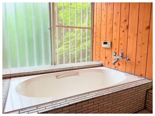 a bath tub in a room with a window at コテージそら豆ん家 in Nasu
