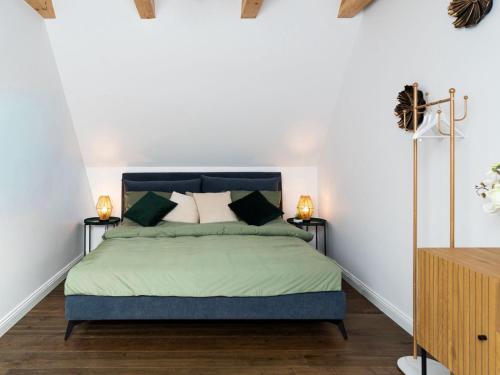a bedroom with a bed with green sheets and two lamps at Küstenzeit Travemünde in Rönnau