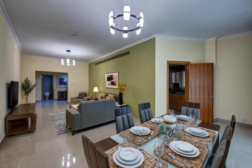 a dining room and living room with a table and chairs at Radiance Premium Suites in Dubai