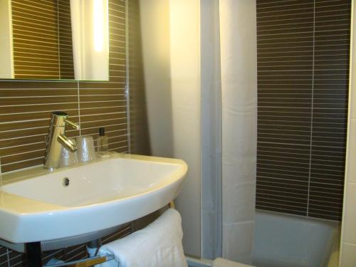 a bathroom with a white sink and a shower at Park Hotel Porto Aeroporto in Maia