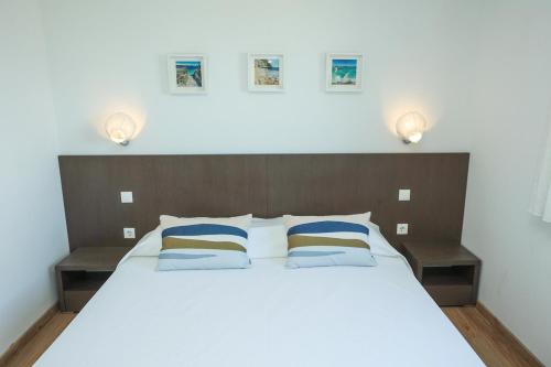 a bedroom with a large white bed with two lamps at Villa Allegra w Private Pool in Škrip
