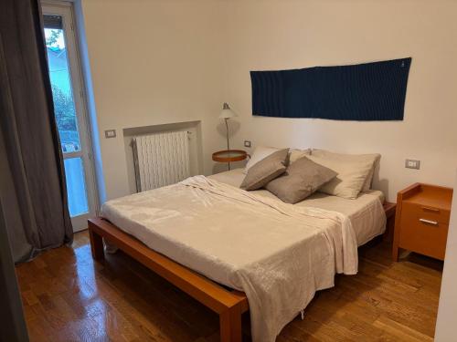 a bedroom with a large bed with a table and a window at Bumbunin in Alba
