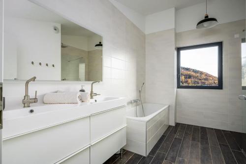 a white bathroom with a tub and a sink at Villa calme avec vue 4 à 8 personnes - salle de sport in Saint-Amarin