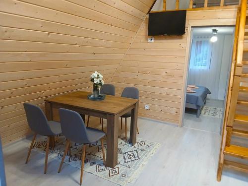 a wooden room with a table with chairs and a television at Котедж Синевир in Synevyr