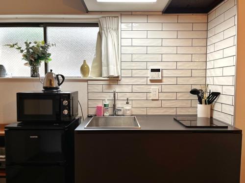 a kitchen with a sink and a microwave at Roppongi Place in Tokyo