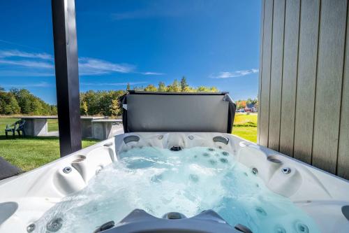 a jacuzzi tub in a yard with a window at Absolute Comfort with Spa & Game Room - Base Camp in Beaupré