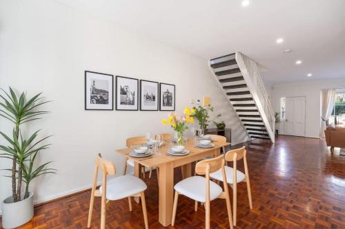 ein Esszimmer mit Tisch und Stühlen und einer Treppe in der Unterkunft 3 Bed Close To City Adelaide Oval Golf Course in North Adelaide