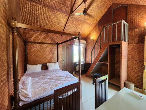 a bedroom with a bed in a room with a staircase at Tusker Valley Bamboo Room Mudumalai by Privacy Homes in Mudumalai National Park