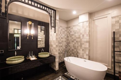 un bagno con una grande vasca e due lavandini di Perana Wellness Resort Chiang Mai a Ban Thung Pong