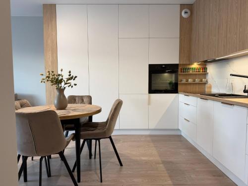 ウォムジャにあるApartament 345の木製のテーブルと椅子が置かれたキッチン