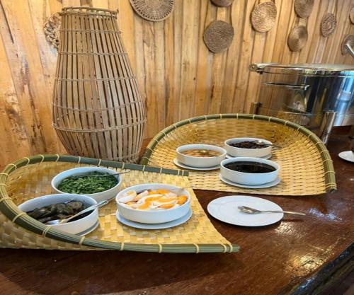 ein Tablett mit Schüsseln Essen auf dem Tisch in der Unterkunft Borneo Beach & Mangrove Resort in Tuaran