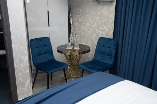 a bedroom with a table and two chairs and a bed at Prime Suites Hotel in Yerevan