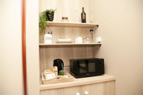 a microwave sitting on a shelf in a kitchen at Pine & Pebble in Centurion