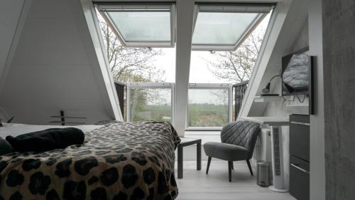a bedroom with a bed and a large window at Logies Jardin Schagen in Schagen