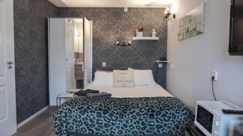a small bedroom with a bed and a tv at Logies Jardin Schagen in Schagen