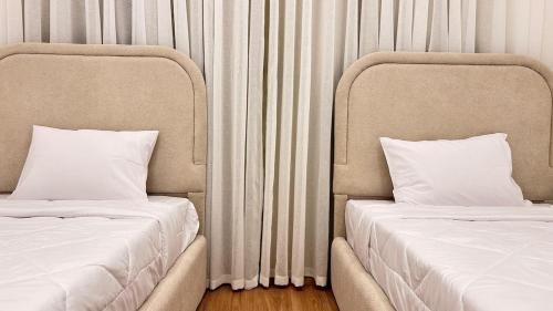 two beds sitting next to each other in a room at Luxurious and hotel-like accommodation with garden view in New cairo
