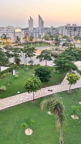 a park with trees and a city in the background at Luxurious and hotel-like accommodation with garden view in New cairo