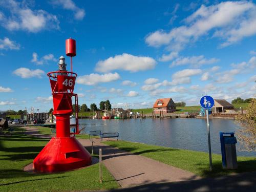a red object on the side of a body of water at Ferienwohnung Butjenter Brise in Stick