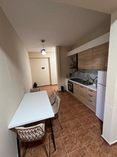 a kitchen with a white table and chairs in it at Open Door Hostel in Tirana
