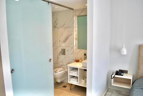 a bathroom with a toilet and a sink at Sonia Hotel & Suites in Kos Town