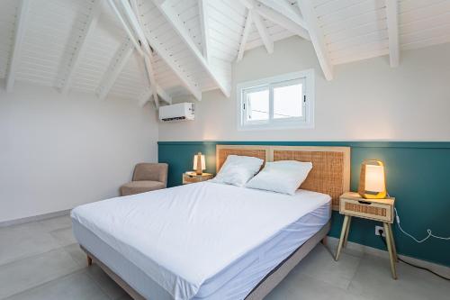 Un dormitorio con una cama grande y una silla. en Kaz Bel Horizon, vue mer panoramique et piscine privée au Gosier, en Le Gosier