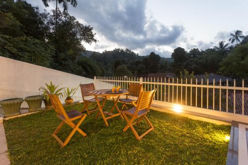 a patio with a table and chairs on the grass at Orchid Villa Kandy in Kandy
