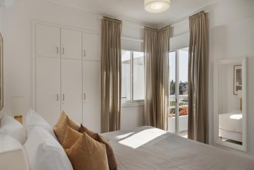 a bedroom with a bed and a large window at Sienna Townhouse by Staycom in Paphos City