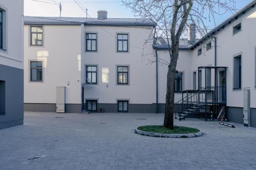 un gran edificio blanco con un árbol en el patio en Colorful Apartments G, en Riga