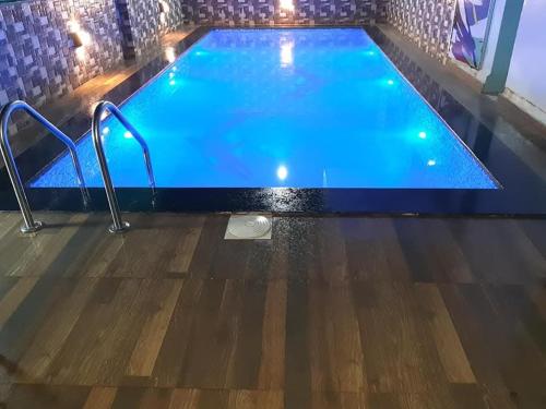 an indoor pool with blue water and wooden floors at GA Bunglow 4Bhk Villa with pool in Lonavala