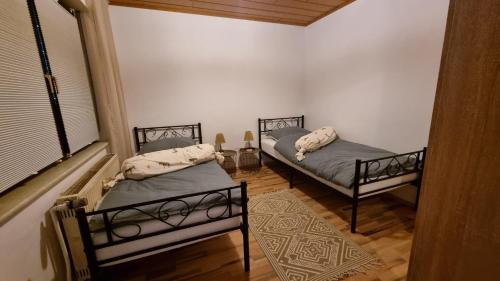 two twin beds in a room with a window at Ferienwohnung Wie dehemm in Sankt Ingbert