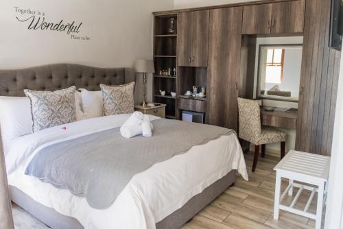 モッセル・ベイにあるLe Port Guesthouseのベッドルーム1室(大型ベッド1台、デスク、椅子付)