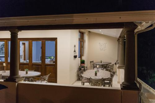 comedor con 2 mesas y sillas en Le Port Guesthouse, en Mossel Bay