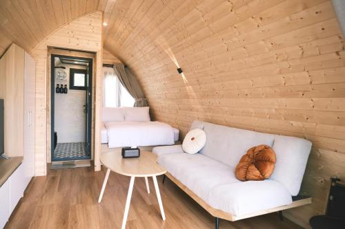 a living room with a couch and a bed at TiTi Beach Pods- Cat Ba Island Beachfront in Cat Ba