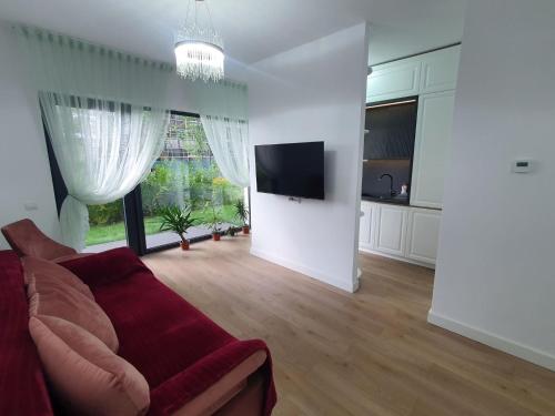 ein Wohnzimmer mit Sofa und Flachbildfernseher in der Unterkunft White Silk - Premium Apartment with free underground parking in Iaşi